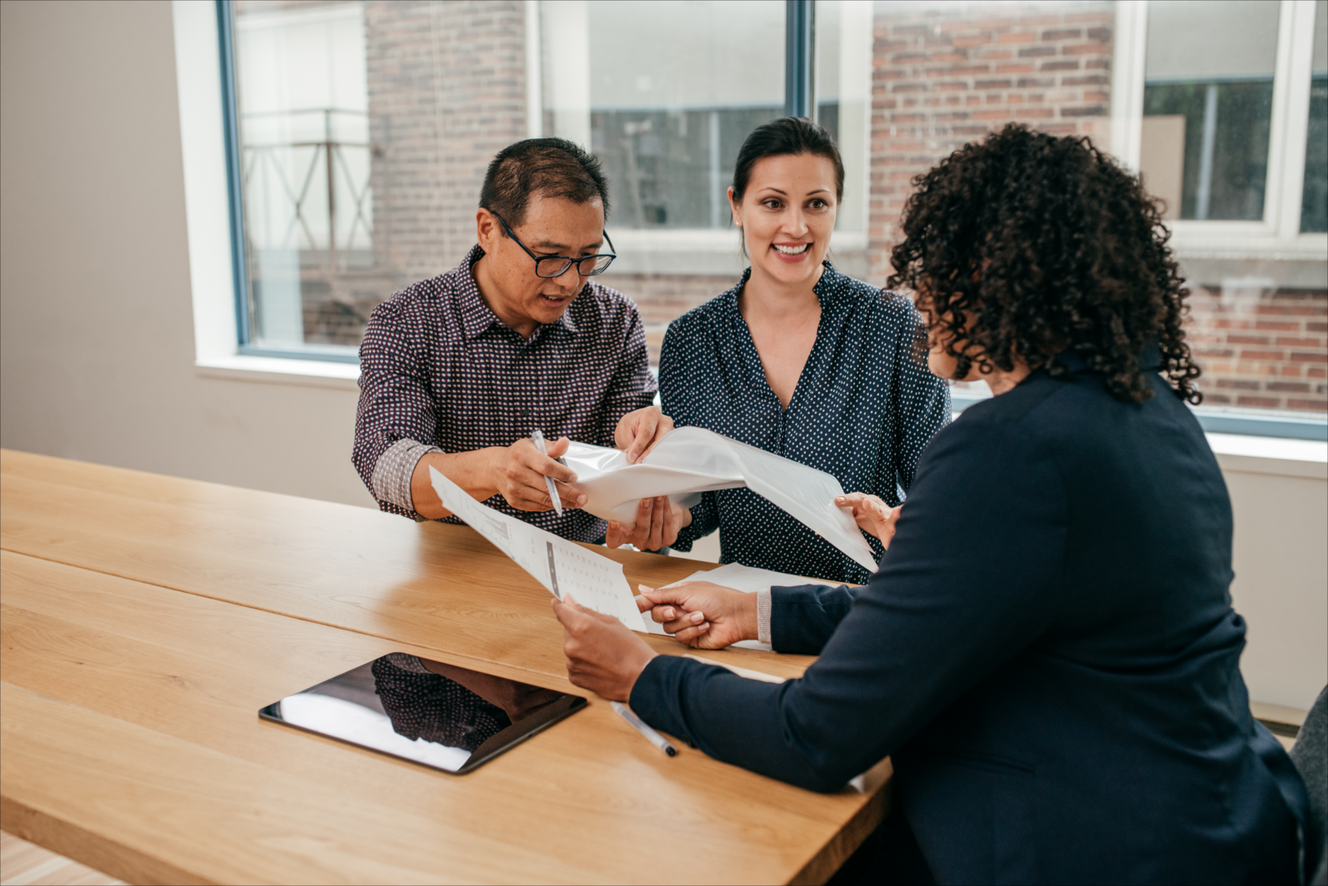 Colleagues discussing documents at a table